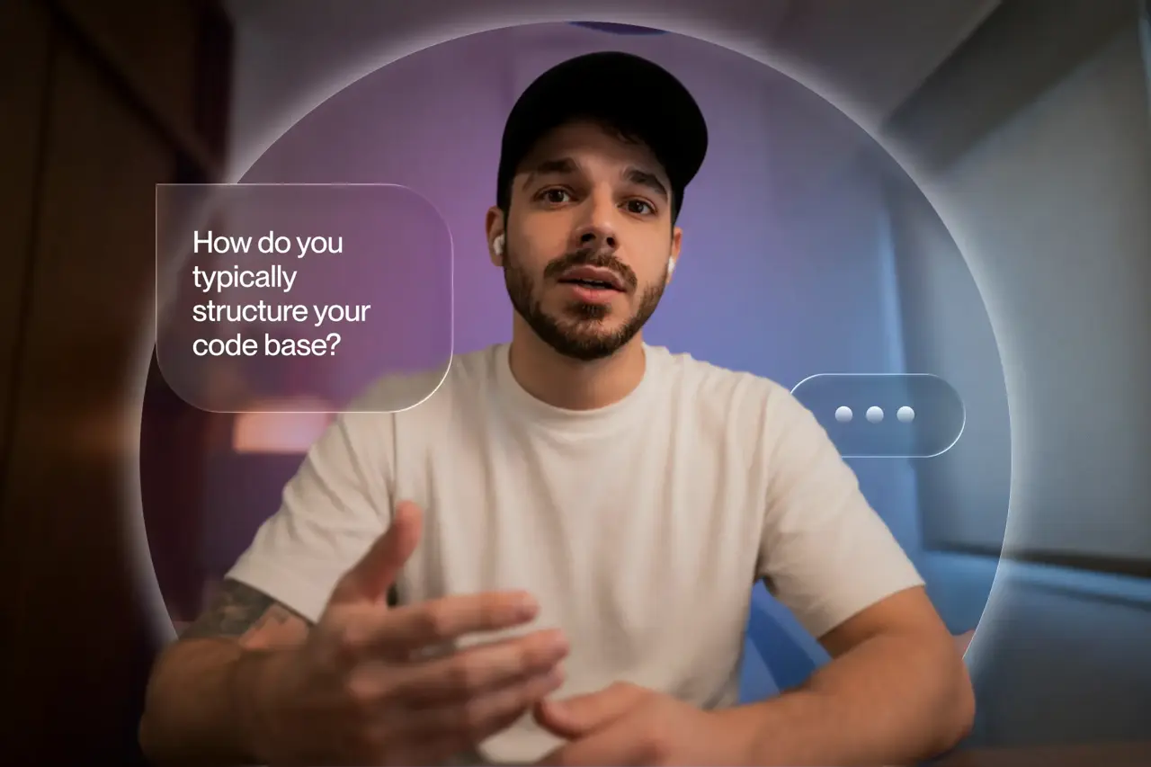 Job seeker in a video interview being asked "How do you typically structure your code base?" on screen.